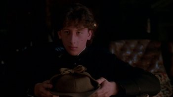 Movie still from “Young Sherlock Holmes” (1985), directed by Barry Levinson – A young man holding a hat in his hands; Close Up shot, Low angle