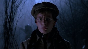 Movie still from “Young Sherlock Holmes” (1985), directed by Barry Levinson – A young man wearing glasses and a hat in the dark; Close Up shot, Low angle
