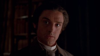 Movie still from “Young Sherlock Holmes” (1985), directed by Barry Levinson – A person wearing a suit and tie; Close Up shot, Over the shoulder angle