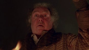 Movie still from “Young Sherlock Holmes” (1985), directed by Barry Levinson – A man with curly hair wearing a brown jacket; Close Up shot, Low angle