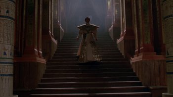 Movie still from “Young Sherlock Holmes” (1985), directed by Barry Levinson – A woman in a gown walking down a set of stairs; Wide shot, Low angle