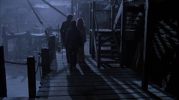 Movie still from “Young Sherlock Holmes” (1985), directed by Barry Levinson – A group of people walking down a wooden walkway; Wide shot, High angle