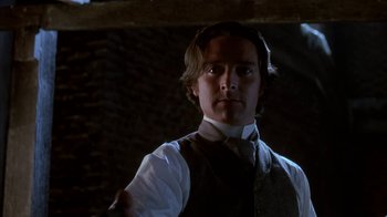 Movie still from “Young Sherlock Holmes” (1985), directed by Barry Levinson – A man wearing a vest and a white shirt; Close Up shot, Low angle