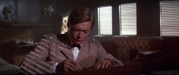 Movie still from “Young Winston” (1972), directed by Richard Attenborough – A man writing on a piece of paper in front of a window; Close Up shot, Low angle