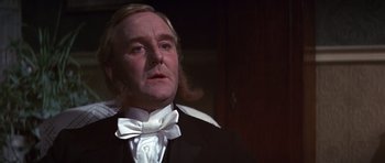 Movie still from “Young Winston” (1972), directed by Richard Attenborough – An old man in a suit and white bow tie; Close Up shot, Low angle
