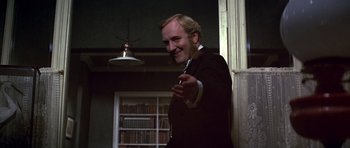Movie still from “Young Winston” (1972), directed by Richard Attenborough – A man in a suit and tie holding a cigarette; Close Up shot, Low angle