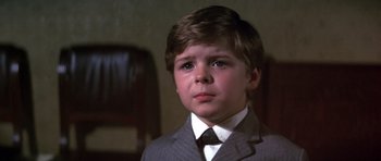 Movie still from “Young Winston” (1972), directed by Richard Attenborough – A young boy in a suit and tie looking up; Close Up shot, High angle