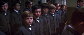 Movie still from “Young Winston” (1972), directed by Richard Attenborough – A group of young men in suits standing in a line; Medium shot, High angle