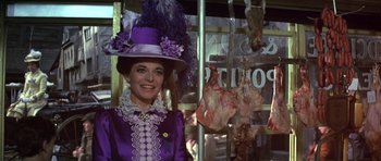 Movie still from “Young Winston” (1972), directed by Richard Attenborough – A woman wearing a purple dress and a purple hat; Medium shot, Over the shoulder angle