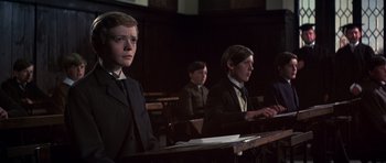 Movie still from “Young Winston” (1972), directed by Richard Attenborough – Three young men in suits sitting at a table; Medium shot, Low angle