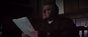 Movie still from “Young Winston” (1972), directed by Richard Attenborough – An older man is looking at a piece of paper; Close Up shot, Low angle