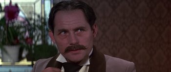 Movie still from “Young Winston” (1972), directed by Richard Attenborough – A person wearing a suit and a tie; Close Up shot, Low angle