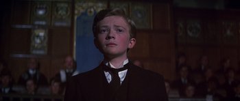 Movie still from “Young Winston” (1972), directed by Richard Attenborough – A boy in a suit and tie looking up; Close Up shot, Low angle