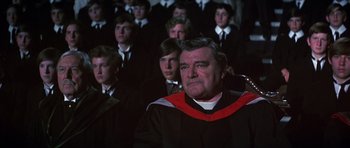 Movie still from “Young Winston” (1972), directed by Richard Attenborough – A group of men in black and red robes; Close Up shot, High angle