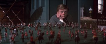 Movie still from “Young Winston” (1972), directed by Richard Attenborough – A man sitting in front of a group of toy soldiers; Medium shot, High angle