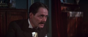 Movie still from “Young Winston” (1972), directed by Richard Attenborough – A person wearing a suit and a bow tie; Close Up shot, Low angle