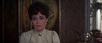 Movie still from “Young Winston” (1972), directed by Richard Attenborough – A woman in a white shirt and a green necklace; Close Up shot, Over the shoulder angle