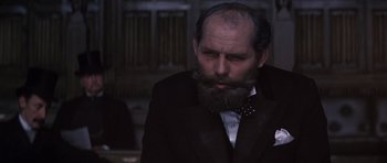 Movie still from “Young Winston” (1972), directed by Richard Attenborough – A man with a beard and a suit and tie; Close Up shot, High angle