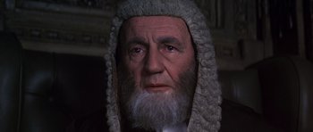 Movie still from “Young Winston” (1972), directed by Richard Attenborough – An old man wearing a wig and a white beard; Close Up shot, High angle