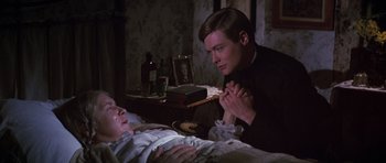 Movie still from “Young Winston” (1972), directed by Richard Attenborough – A man and a woman praying in a dark room; Medium shot, High angle
