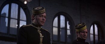 Movie still from “Young Winston” (1972), directed by Richard Attenborough – A man in a military uniform is looking at the camera; Close Up shot, Over the shoulder angle