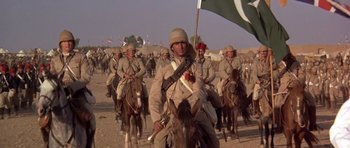 Movie still from “Young Winston” (1972), directed by Richard Attenborough – A group of men on horses with flags on their backs; Wide shot, Low angle