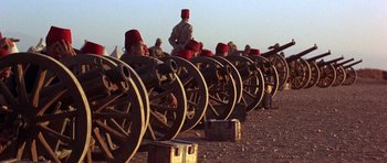 Movie still from “Young Winston” (1972), directed by Richard Attenborough – A group of men standing next to each other; Extreme Wide shot, Low angle