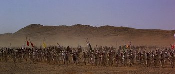 Movie still from “Young Winston” (1972), directed by Richard Attenborough – A large group of people marching on a dirt field; Extreme Wide shot, High angle