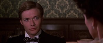 Movie still from “Young Winston” (1972), directed by Richard Attenborough – A person wearing a suit and bow tie; Close Up shot, Over the shoulder angle