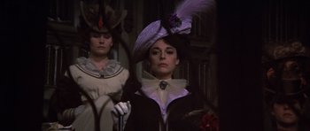 Movie still from “Young Winston” (1972), directed by Richard Attenborough – A woman wearing a hat and holding a cane in front of another woman wearing a hat; Close Up shot, Low angle