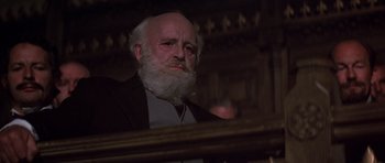 Movie still from “Young Winston” (1972), directed by Richard Attenborough – An old man with a beard is sitting in a chair; Close Up shot, Low angle