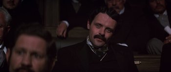 Movie still from “Young Winston” (1972), directed by Richard Attenborough – A man in a suit and tie with a mustache; Close Up shot, Low angle