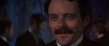 Movie still from “Young Winston” (1972), directed by Richard Attenborough – A person wearing a suit and tie; Close Up shot, Over the shoulder angle