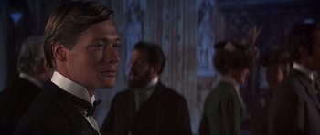 Movie still from “Young Winston” (1972), directed by Richard Attenborough – A man in a suit standing next to two other men in a suit; Close Up shot, Over the shoulder angle