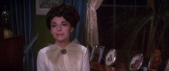 Movie still from “Young Winston” (1972), directed by Richard Attenborough – A woman in a white dress sitting in front of a window; Close Up shot, Over the shoulder angle