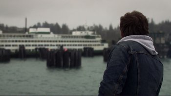 Movie still from “Your Sister's Sister” (2011), directed by Lynn Shelton – A man standing in front of a boat in a body of water; Medium shot, Over the shoulder angle