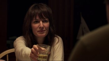 Movie still from “Your Sister's Sister” (2011), directed by Lynn Shelton – A woman sitting at a table holding a glass; Close Up shot, Over the shoulder angle