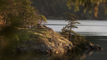 Movie still from “Your Sister's Sister” (2011), directed by Lynn Shelton – A body of water surrounded by trees and rocks; Extreme Wide shot, High angle