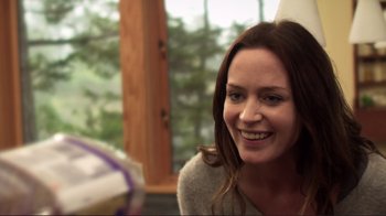 Movie still from “Your Sister's Sister” (2011), directed by Lynn Shelton – A woman smiling for the camera while sitting in a chair; Close Up shot, Over the shoulder angle