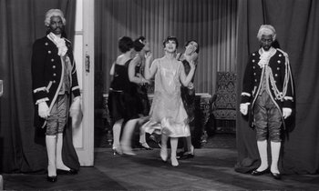 Movie still from “Yoyo” (1965), directed by Pierre Étaix – A group of people standing in a living room; Wide shot, Low angle