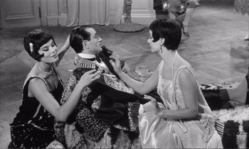 Movie still from “Yoyo” (1965), directed by Pierre Étaix – A man and two women are getting ready for a party; Medium shot, High angle