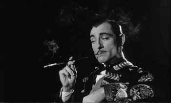 Movie still from “Yoyo” (1965), directed by Pierre Étaix – A black and white photo of a man smoking a pipe; Close Up shot, Low angle