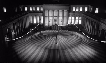 Movie still from “Yoyo” (1965), directed by Pierre Étaix – A black - and - white photo of an open umbrella; Extreme Wide shot, High angle