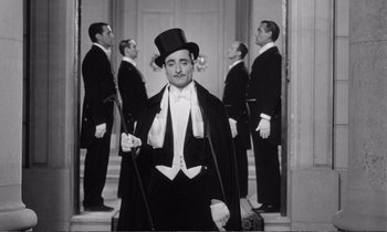 Movie still from “Yoyo” (1965), directed by Pierre Étaix – A group of men standing next to each other in tuxedos; Medium shot, Low angle