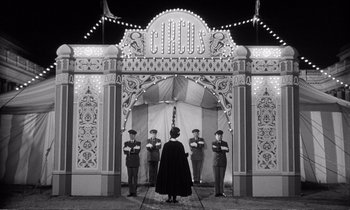 Movie still from “Yoyo” (1965), directed by Pierre Étaix – A group of men standing in front of a circus tent; Wide shot, Low angle