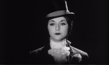 Movie still from “Yoyo” (1965), directed by Pierre Étaix – A black and white photo of a woman wearing a top hat; Close Up shot, Low angle