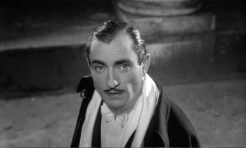 Movie still from “Yoyo” (1965), directed by Pierre Étaix – A man with a mustache wearing a suit and tie; Close Up shot, Low angle