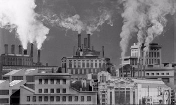 Movie still from “Yoyo” (1965), directed by Pierre Étaix – Smoke billows out of the stacks of an industrial building; Extreme Wide shot, Low angle