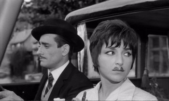 Movie still from “Yoyo” (1965), directed by Pierre Étaix – A man and a woman are standing next to each other; Close Up shot, Low angle