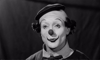 Movie still from “Yoyo” (1965), directed by Pierre Étaix – A man with a clown makeup on his face; Close Up shot, Low angle
